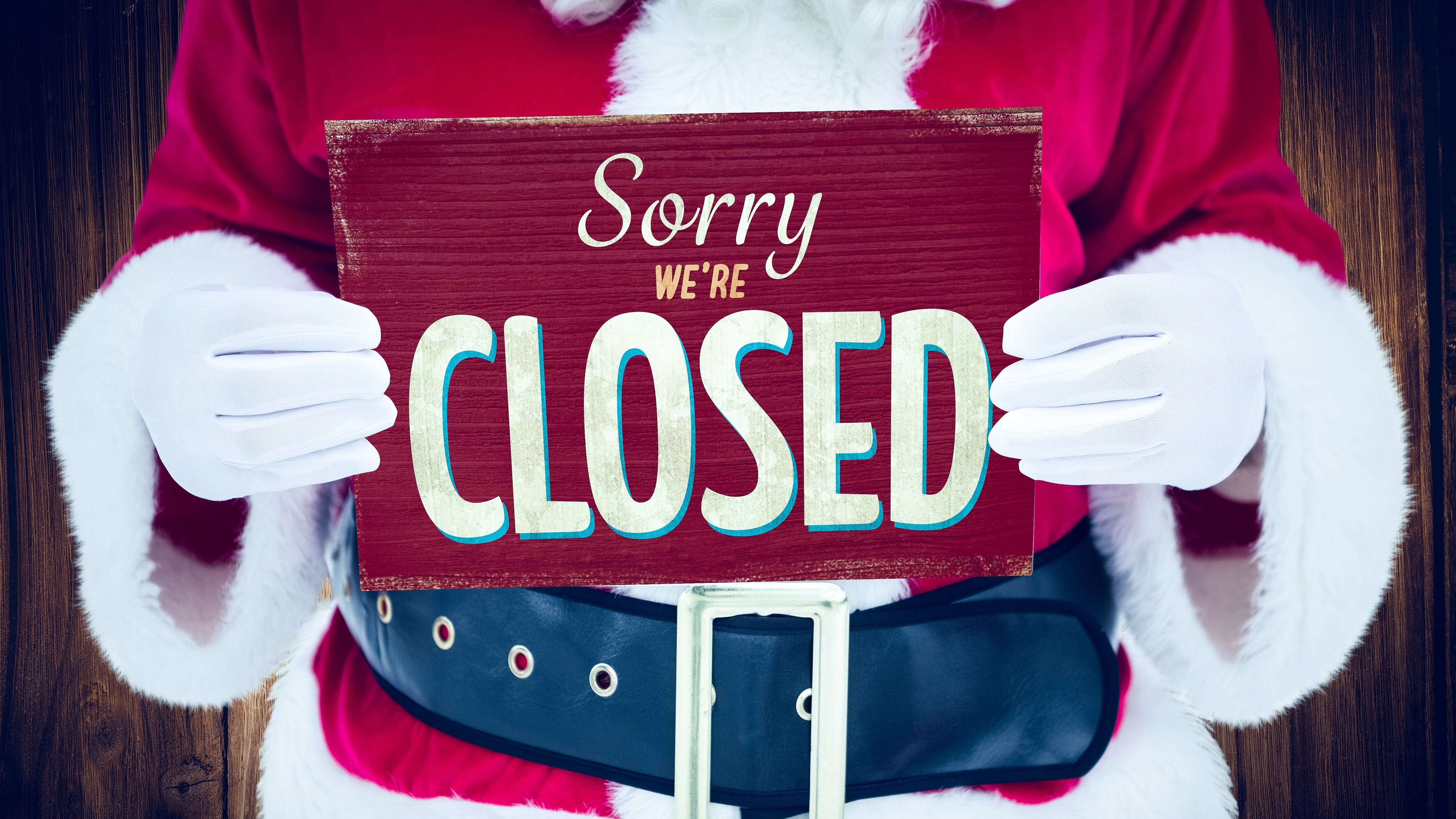 Santa holding closed sign.